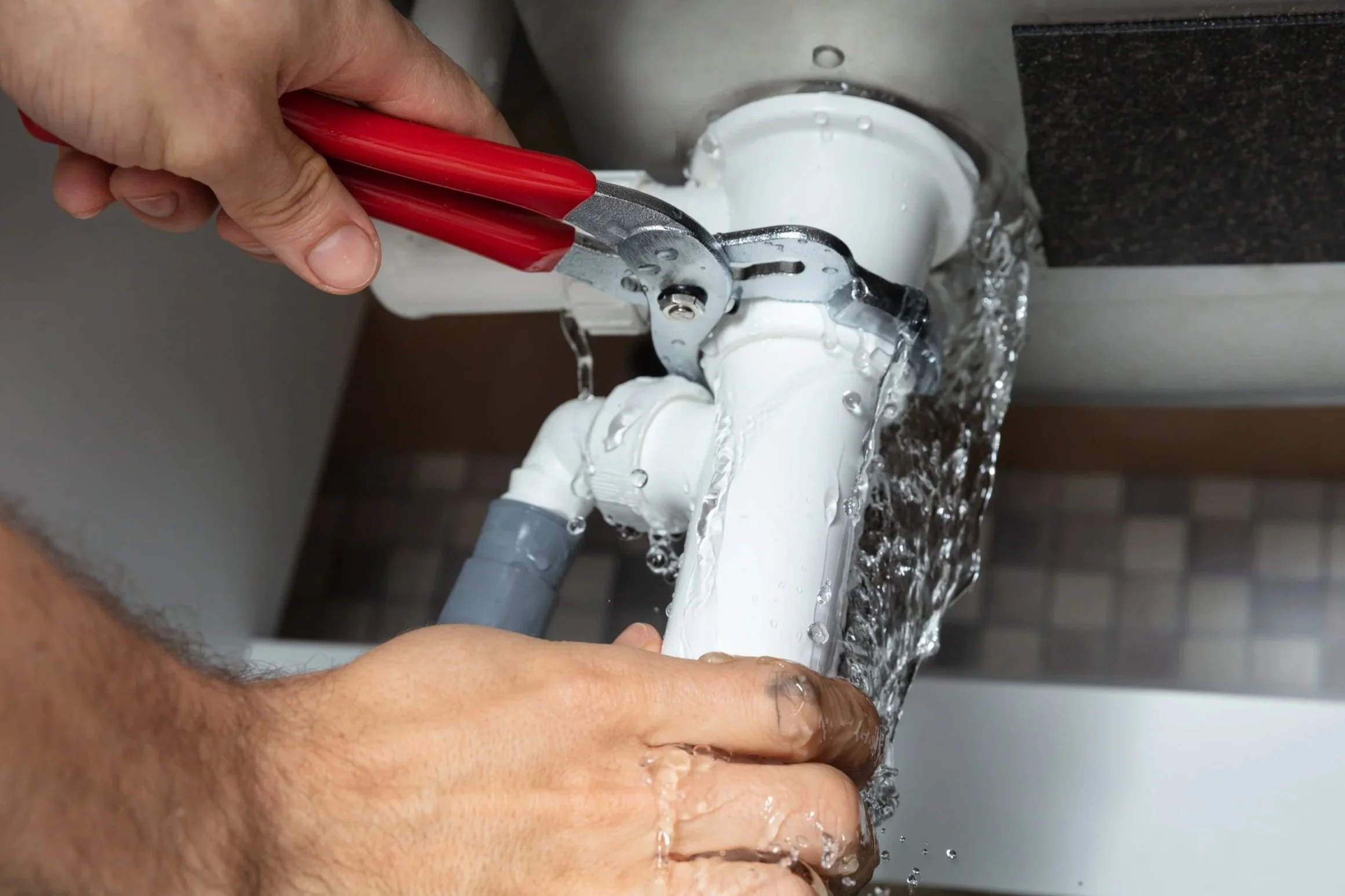 En rørlegger som fikser et lekk rør ved å bruke en rørkutter