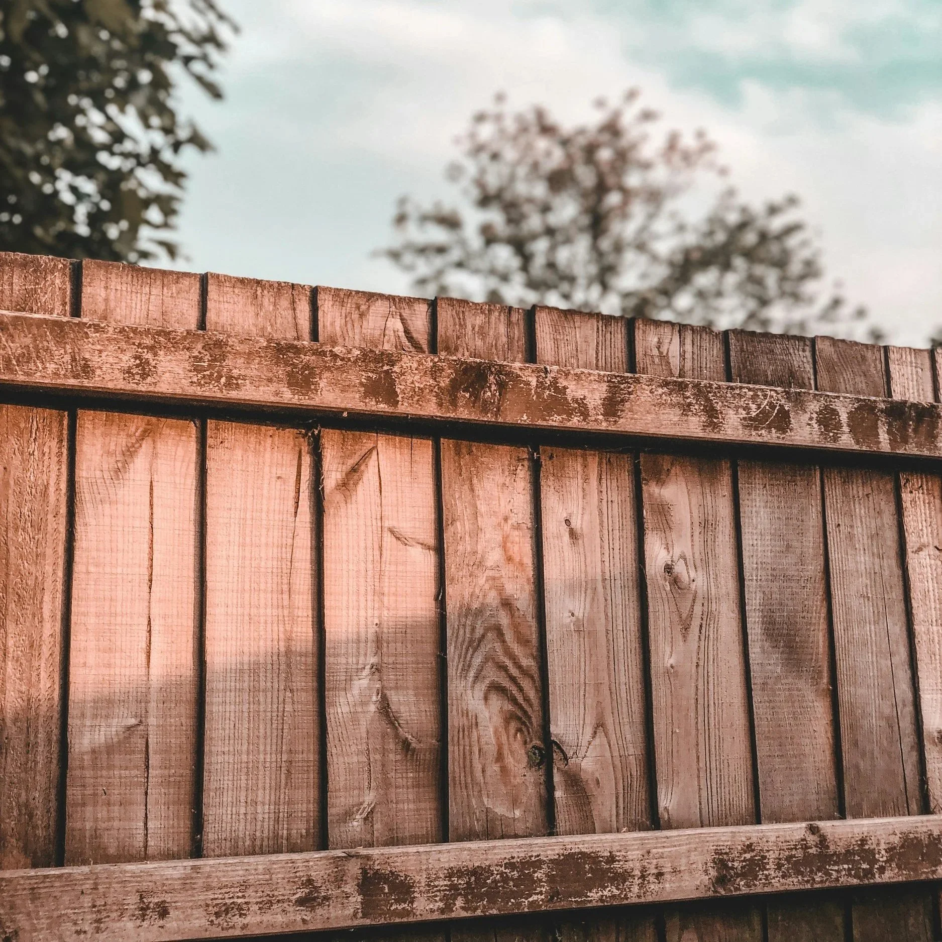 Aging wood fence with visible weathering illustrating how North Carolina humidity accelerates fence rot, deterioration, and structural wood damage.