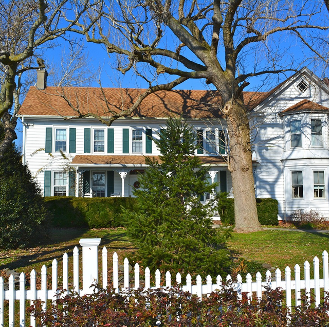 suburban backyard with tall wood privacy fence and measuring tape