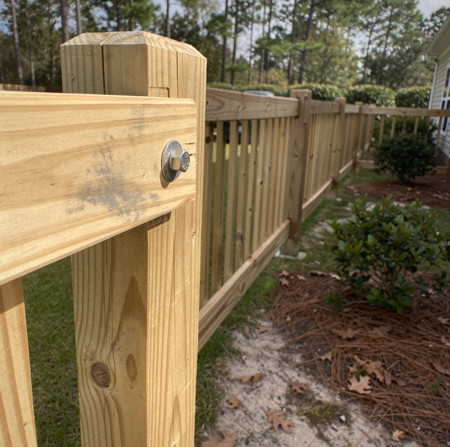 storm damaged wooden fence panels scattered across grass
