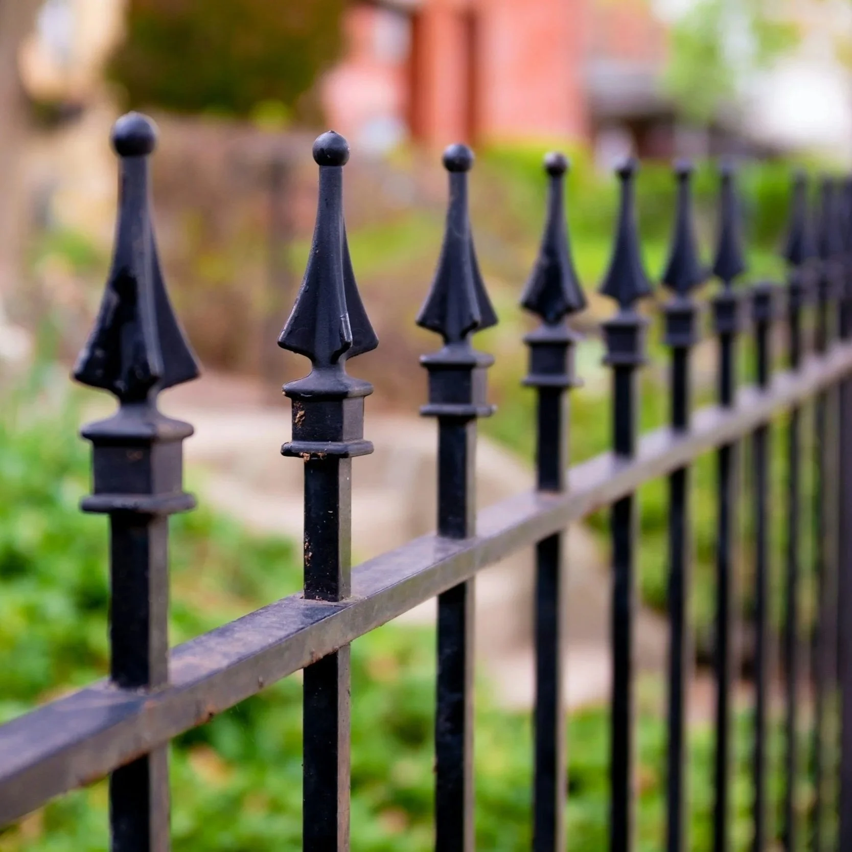 Black metal fence with decorative spear tops, representing secure yet visually appealing perimeter fencing designed for strength, durability, and architectural enhancement.