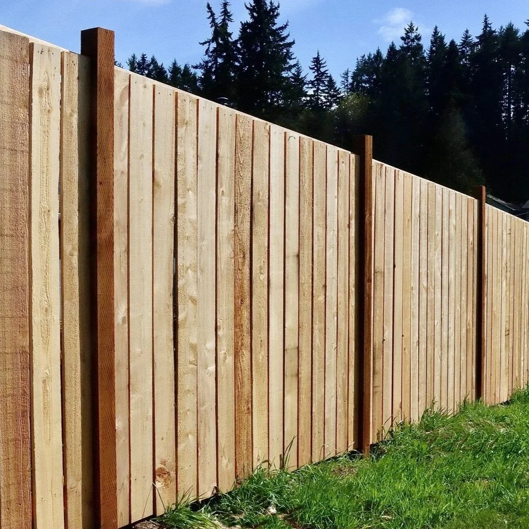 Long wooden fence panels aligned evenly in grassy area, illustrating successful fence reinstallation providing durability, privacy, and improved layout for property boundaries.