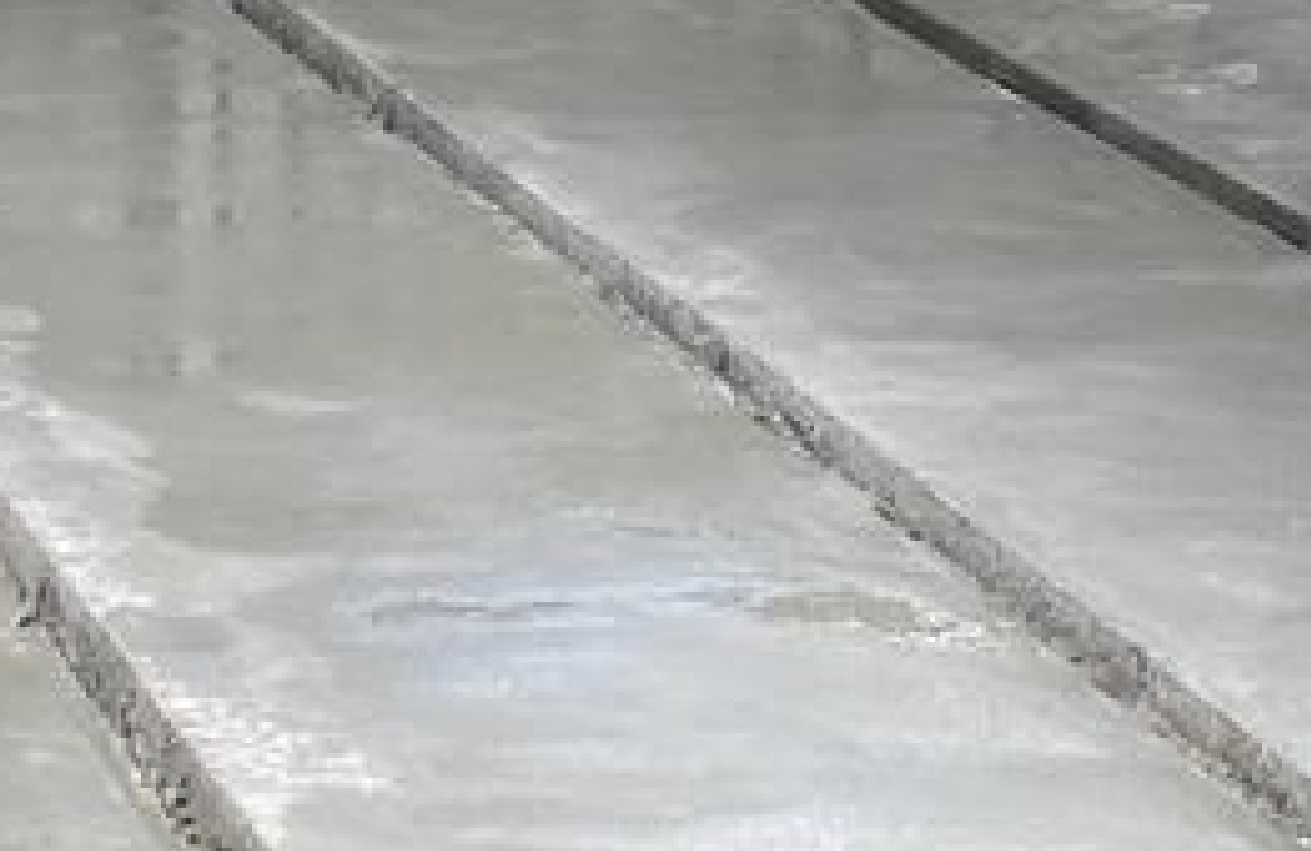Close-up of a tiled floor with beige and light-colored tiles.