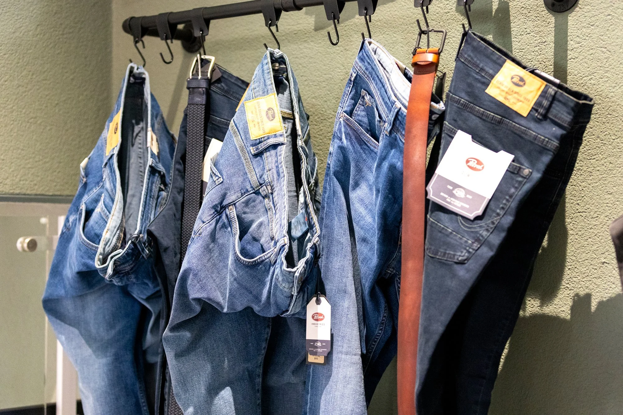 Jeanshosen hängen an einer Garderobe in einem Geschäft.