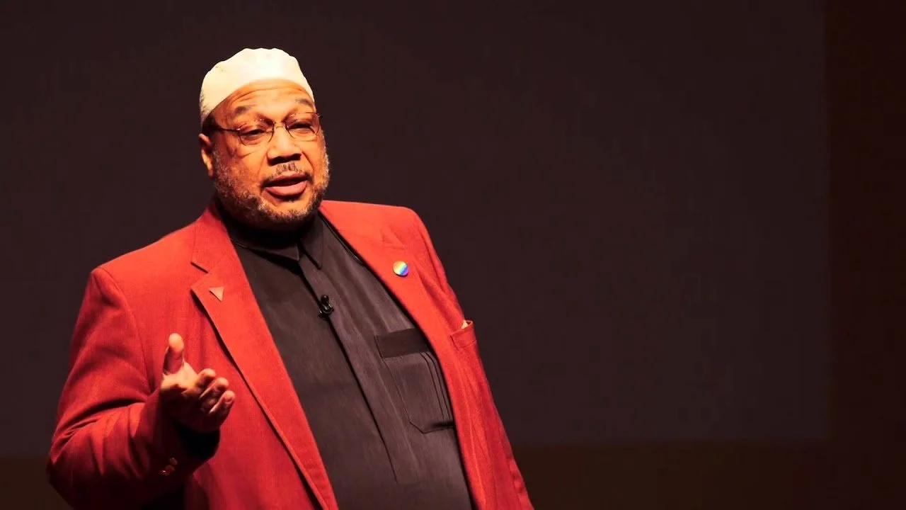 Thumbnail of "Islamic Spiritual Revival and Shari'ah Legal Reform | Daayiee Abdullah | TEDxClaremontColleges"

Imam Daayiee Abdullah, featuring glasses, a short beard, and a black thobe with a white cap (kufi), delivering a presentation against a dar