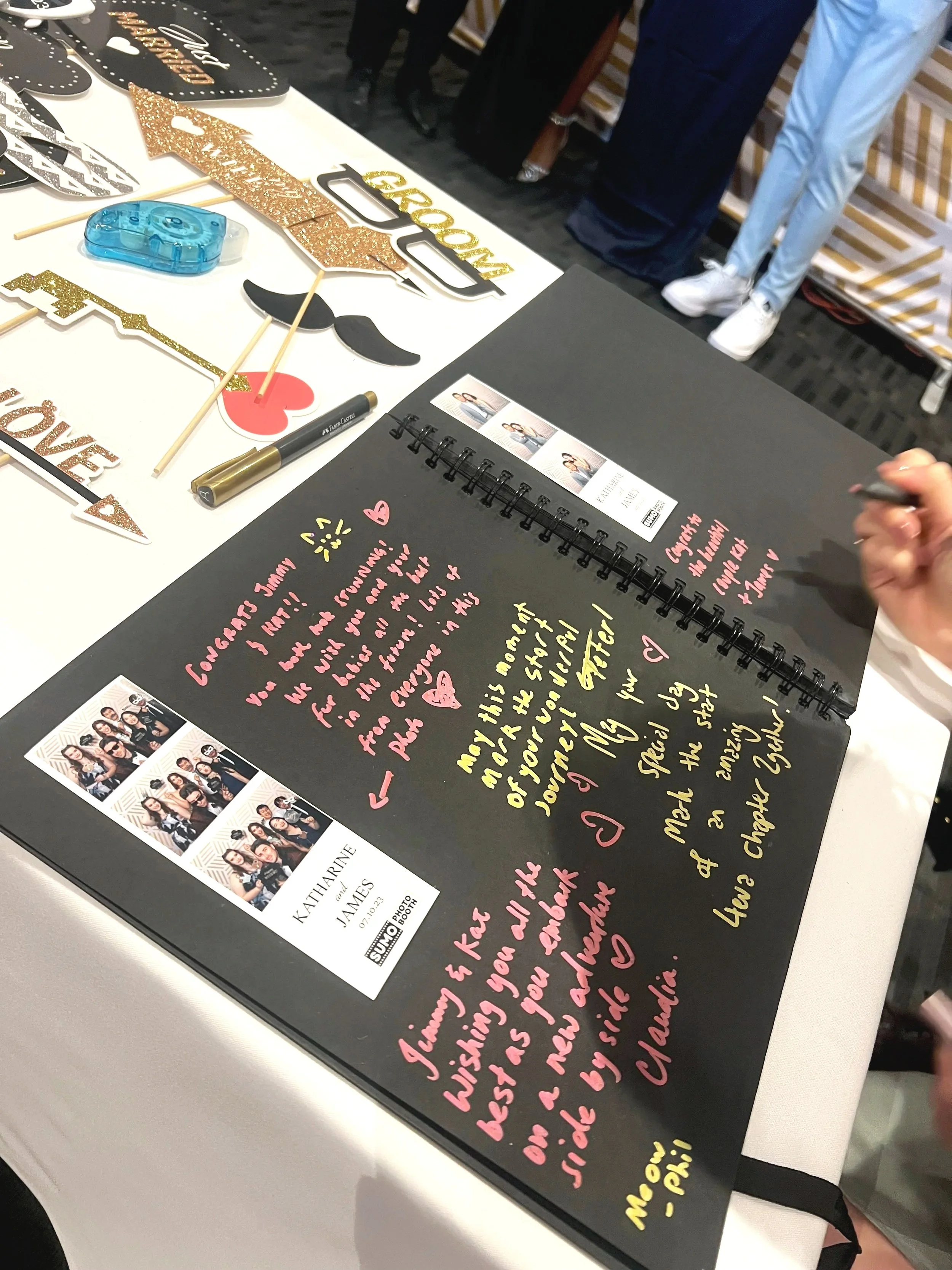 Open scrapbook with handwritten message, photo booth pictures, and decorative props for celebration