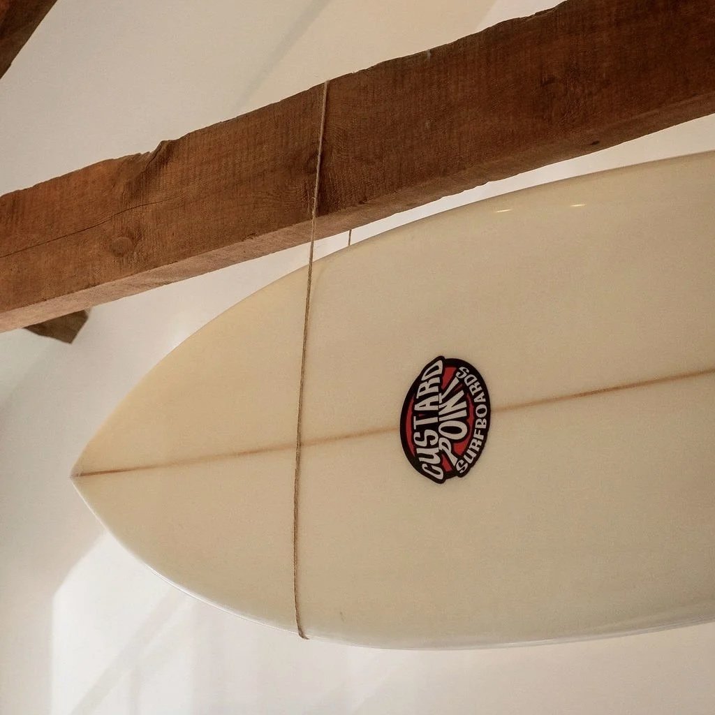 Surfboard hanging from beams — nod to Cornwall’s surf culture at Stargazey.