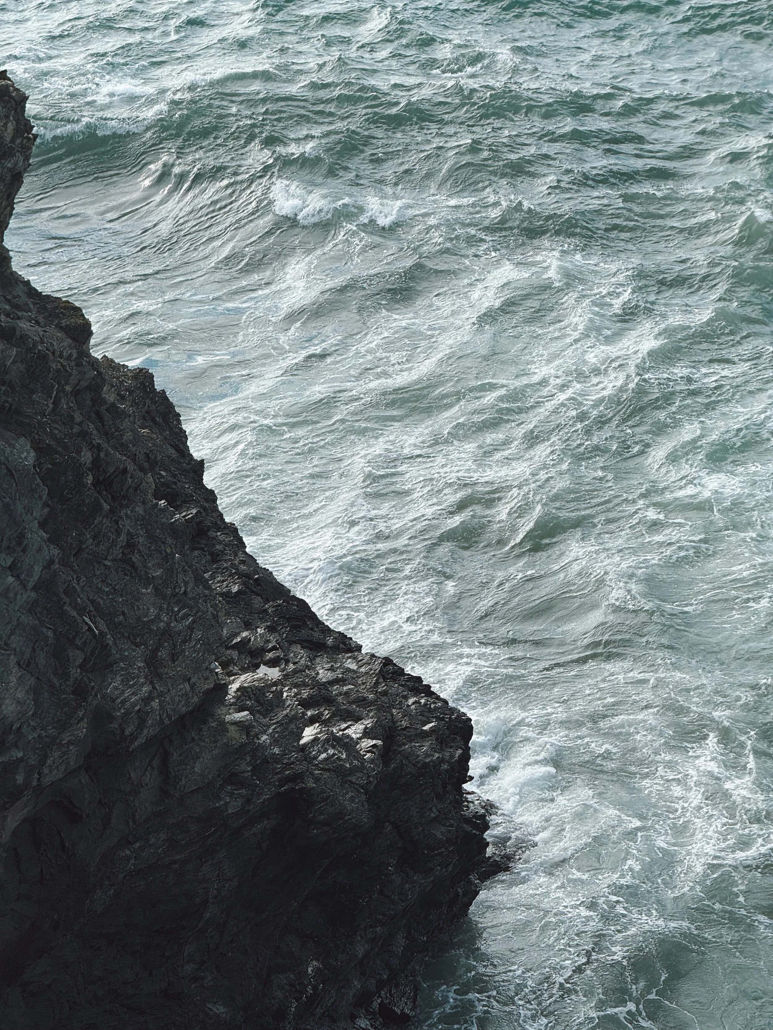 Rocky cliffs and ocean below Watergate Bay on the north Cornish coast.