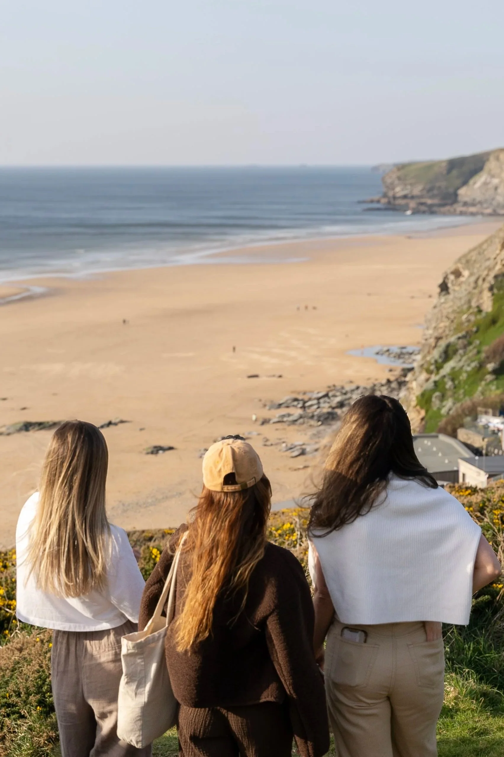 Three guests overlooking Mawgan Porth beach from the coastal path near Stargazey