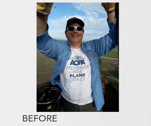 A man smiling and taking a selfie, wearing sunglasses and a blue jacket, with a hot air balloon basket in the background.
