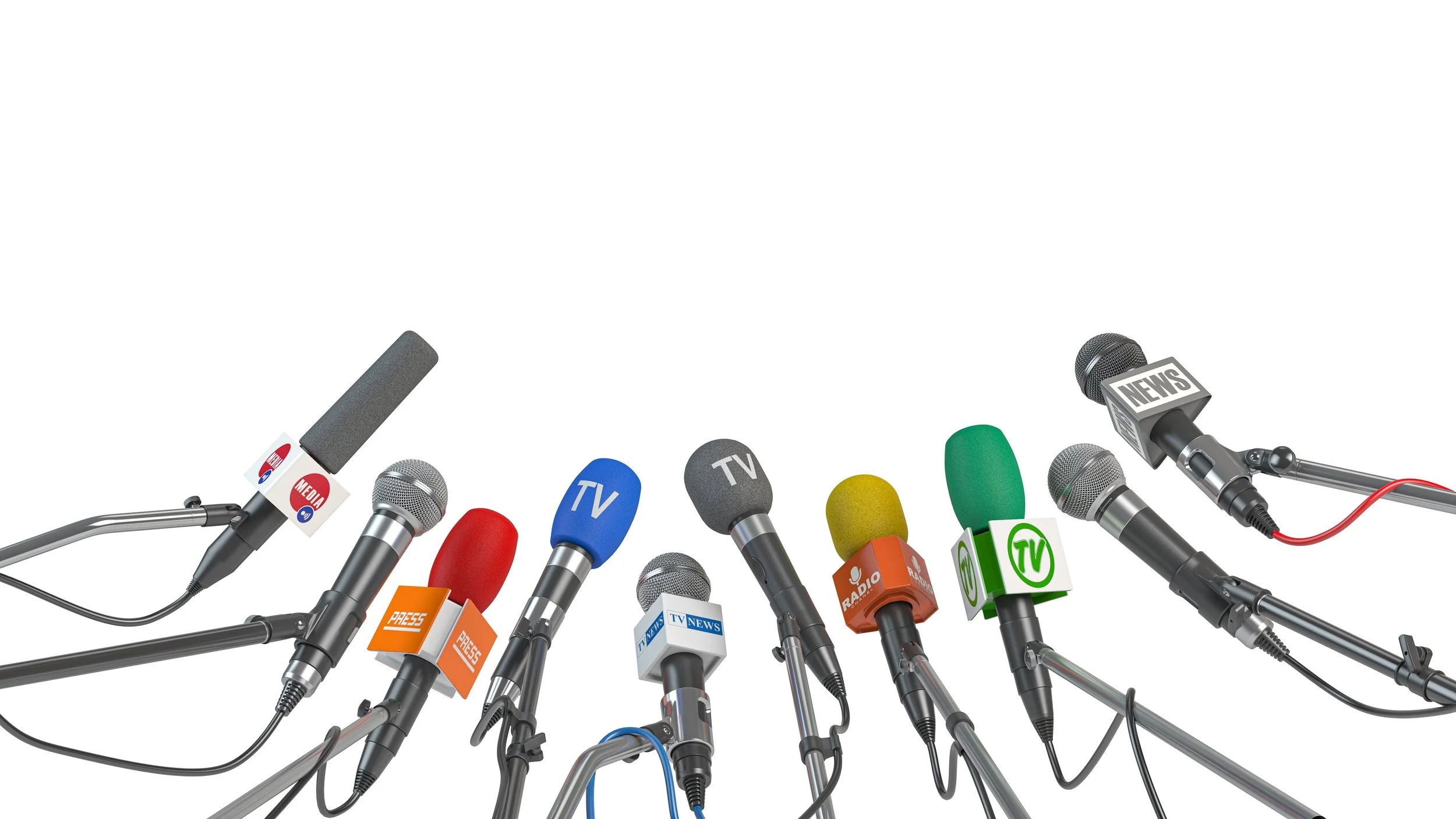 Multiple microphones with different logos representing news and media organizations, arranged on stands for a press conference or media event.