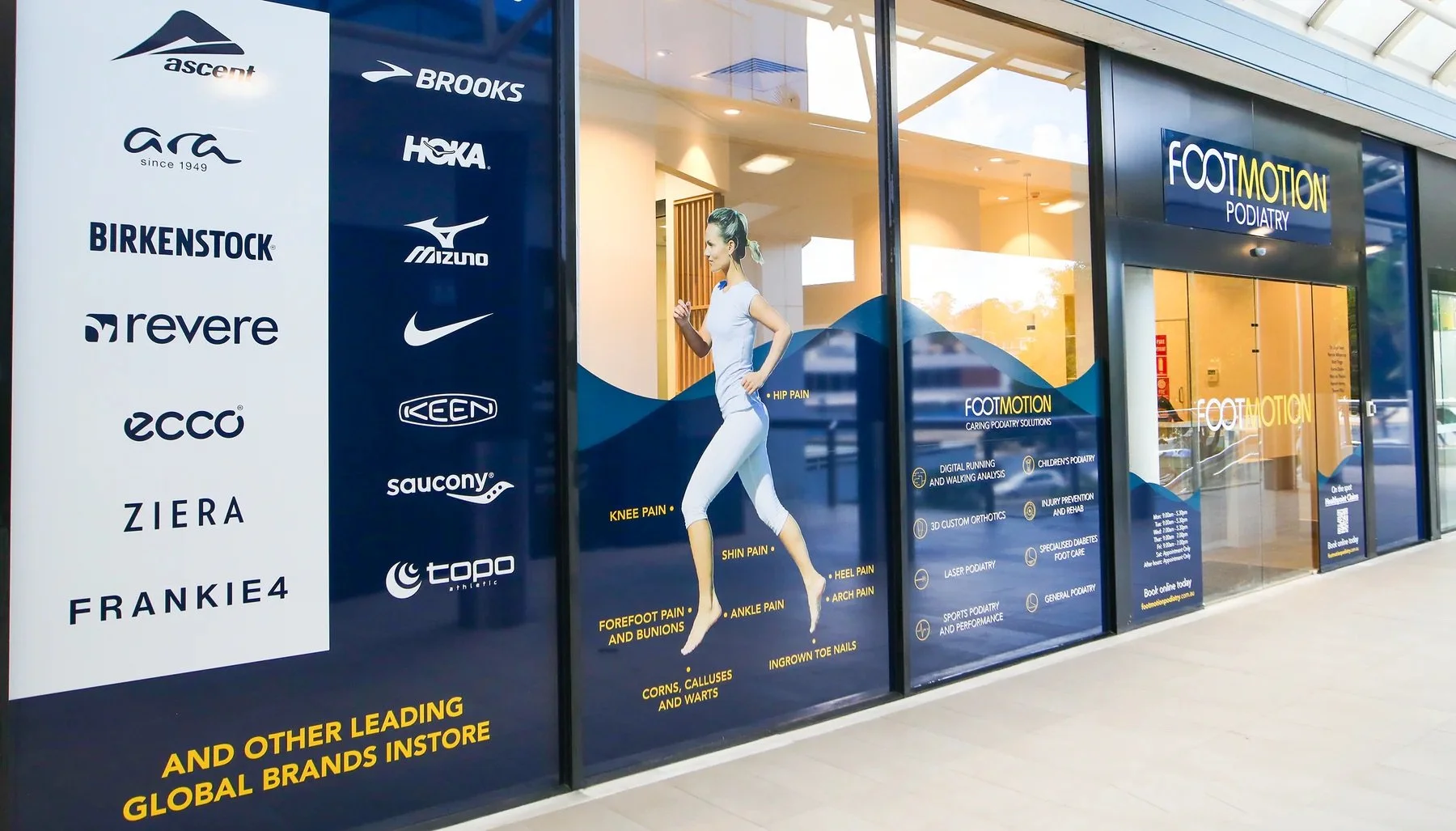 Storefront for Foot Motion Podiatry, featuring logos of brands and an illustration of a woman running, highlighting common foot problems like knee pain, heel pain, and ingrown toenails.
