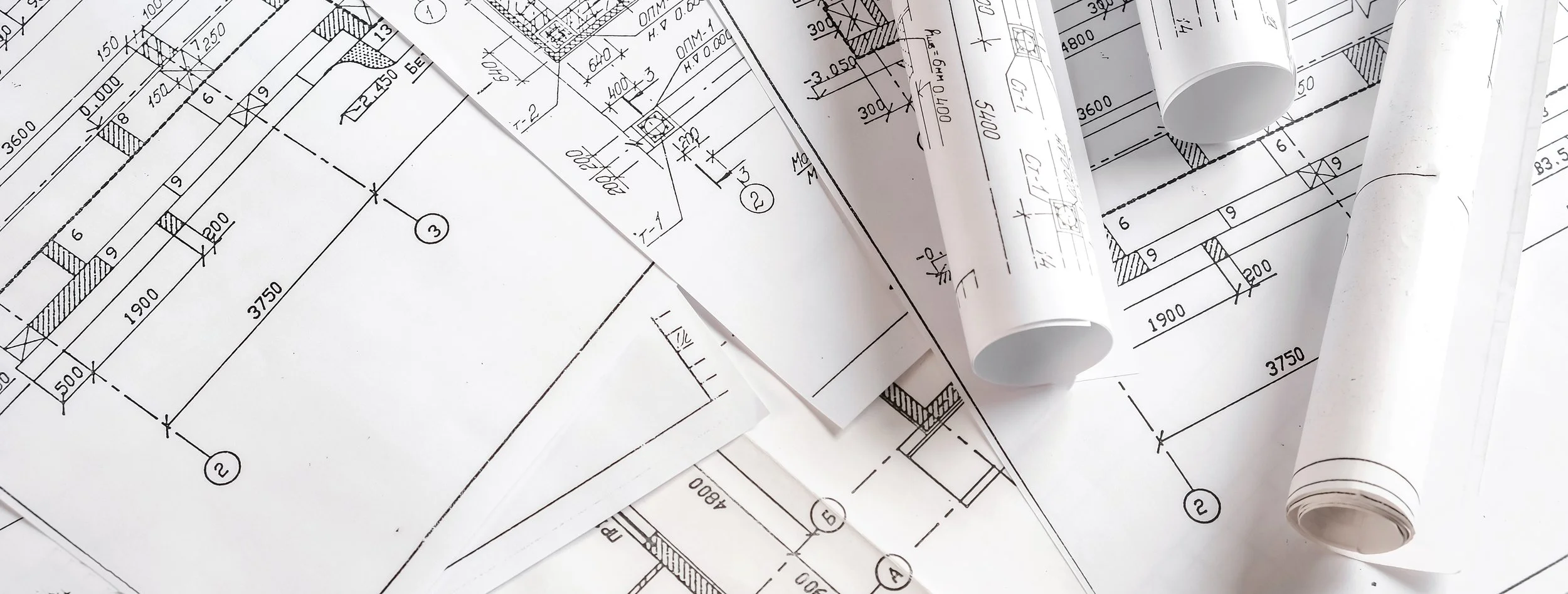 Architectural blueprints and rolled-up drawings on a table.