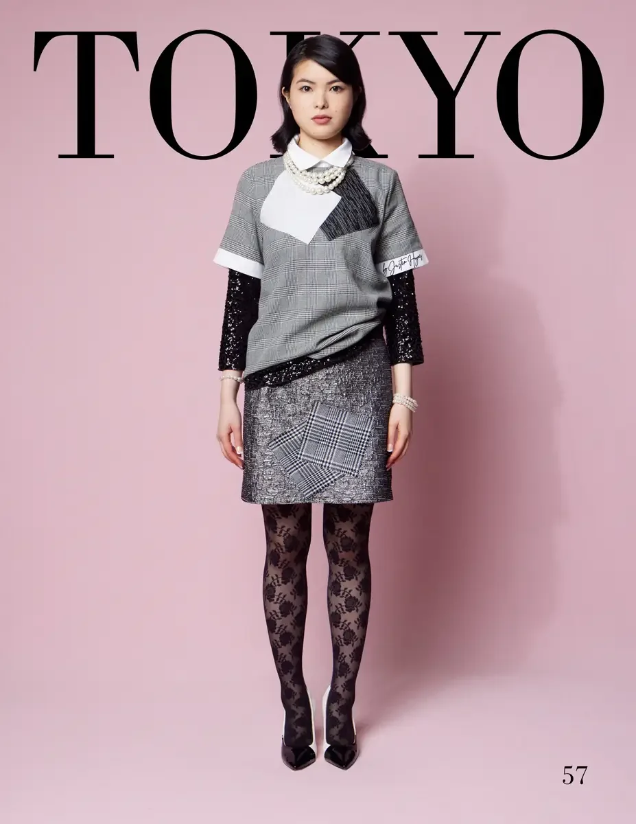 JUS10H 2025 Tokyo lookbook, a female model wearing a gray prince-of-wales plaid short-sleeve top with black pleated and white color-block patchwork panels and a script logo, layered over a white collared shirt with black sequin long sleeves, a silver
