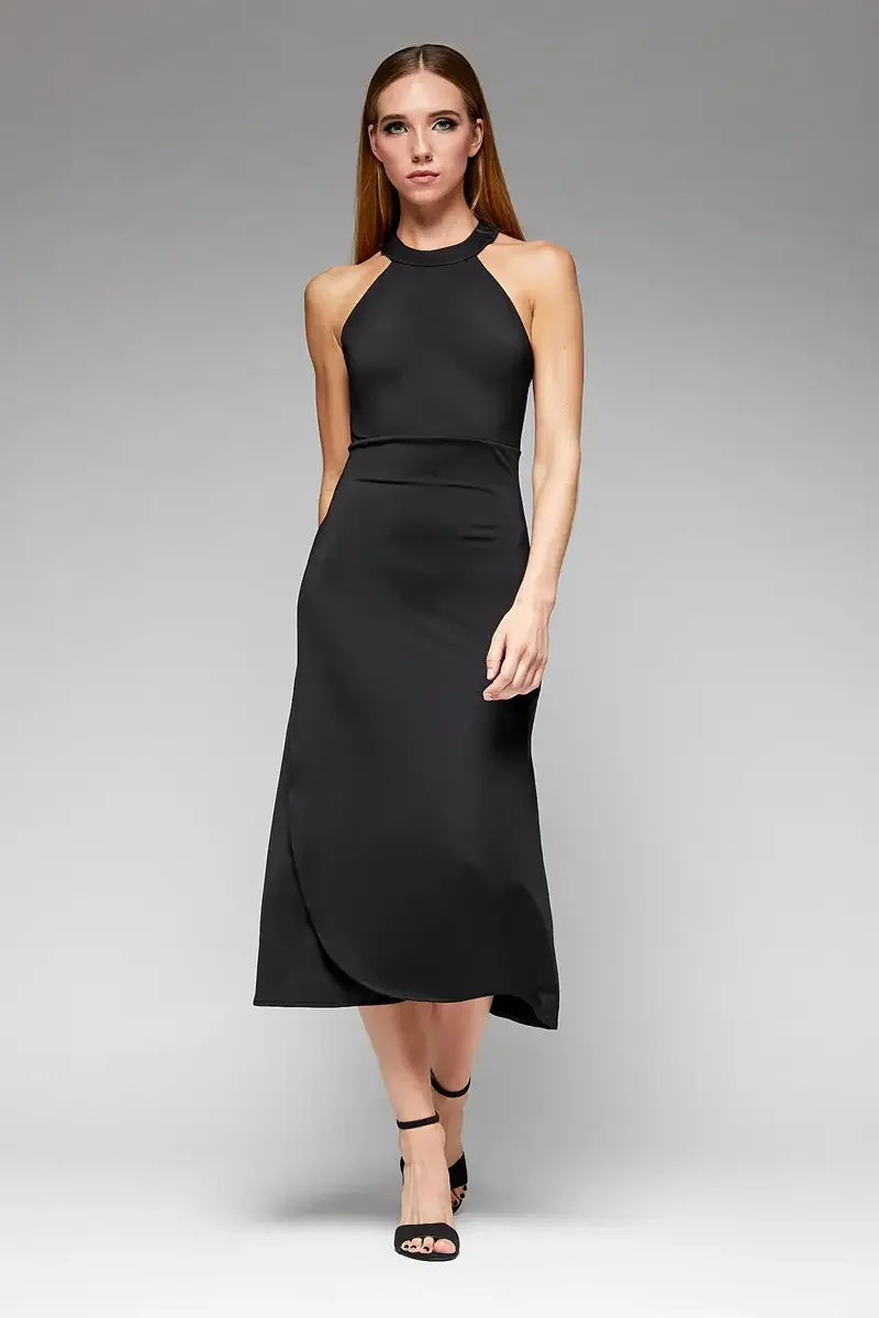 Minika Ko lookbook, black halter midi dress, front view, high halter neckline with strap detail, horizontal seam at waist, flared A-line skirt with curved asymmetric hem, smooth synthetic fabric, photographed by Scott Parker Photo
