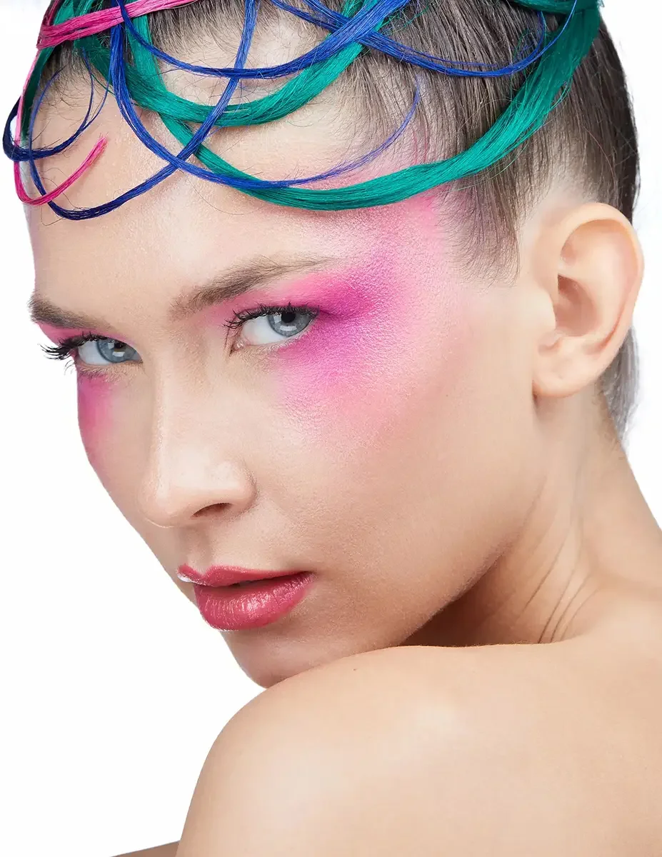 A close-up beauty portrait featuring bold pink eye and cheek makeup with sculptural pink, blue, and teal hair extensions, photographed by Scott Parker Photo.