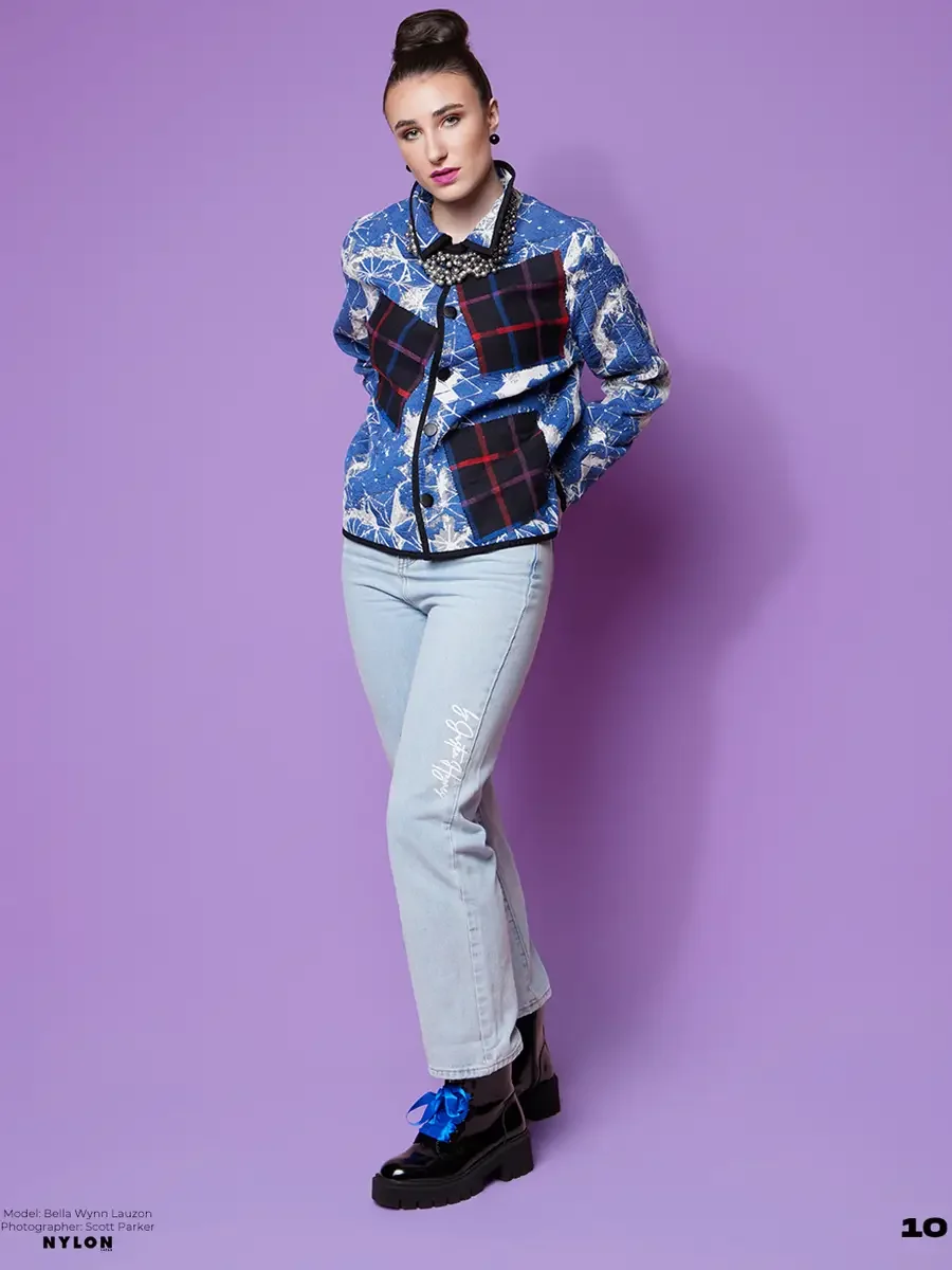 JUS10H 2025 Nylon Japan feature, model in blue snowflake and geometric print cropped jacket with navy tartan patchwork panels and crystal collar necklace, light blue JUS10H script jeans, black patent platform boots with blue ribbon detail, lavender b