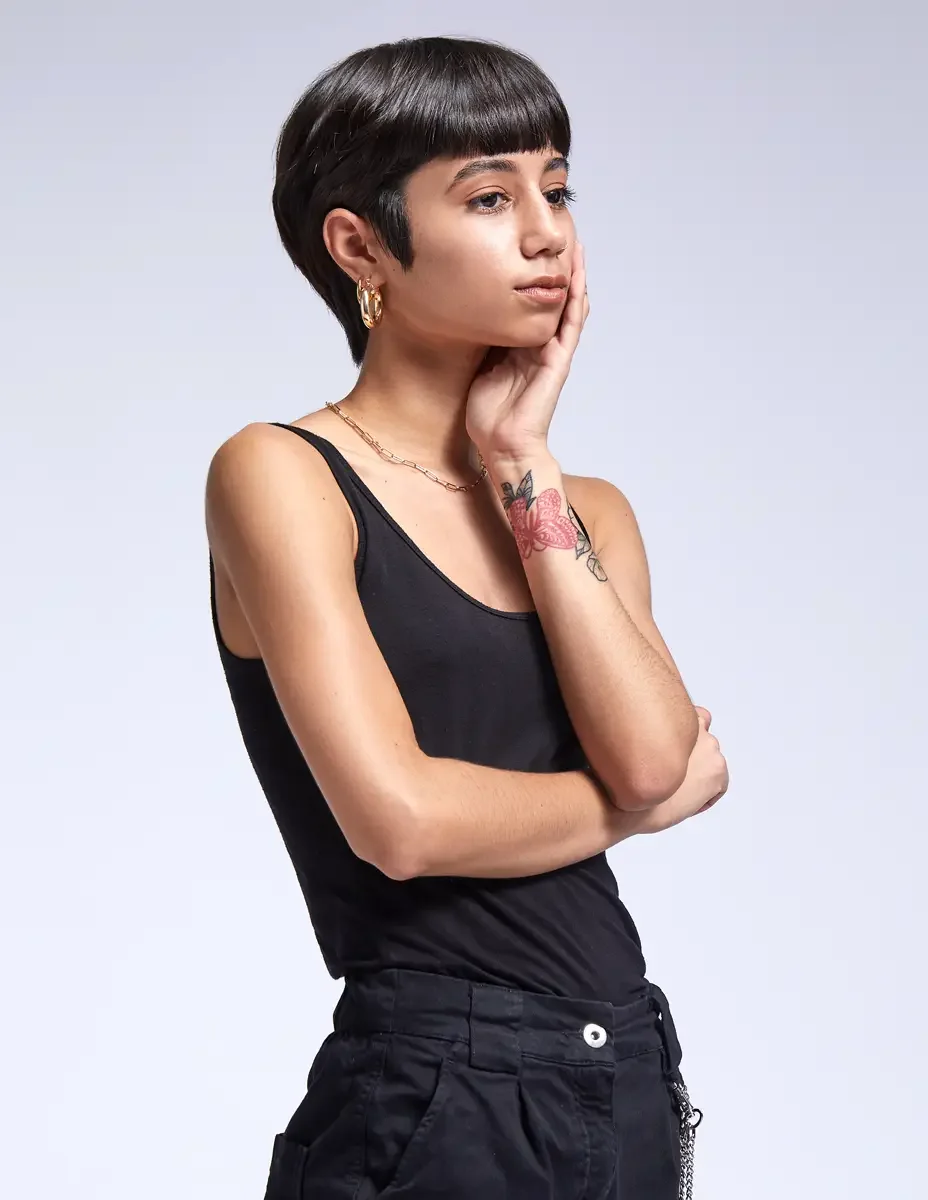 Eloissa, portrait, black tank, gold hoop earrings and chain necklace, pink floral wrist tattoo, East Williamsburg studio test shoot, makeup by Schanica Pickens, photographed by Scott Parker Photo