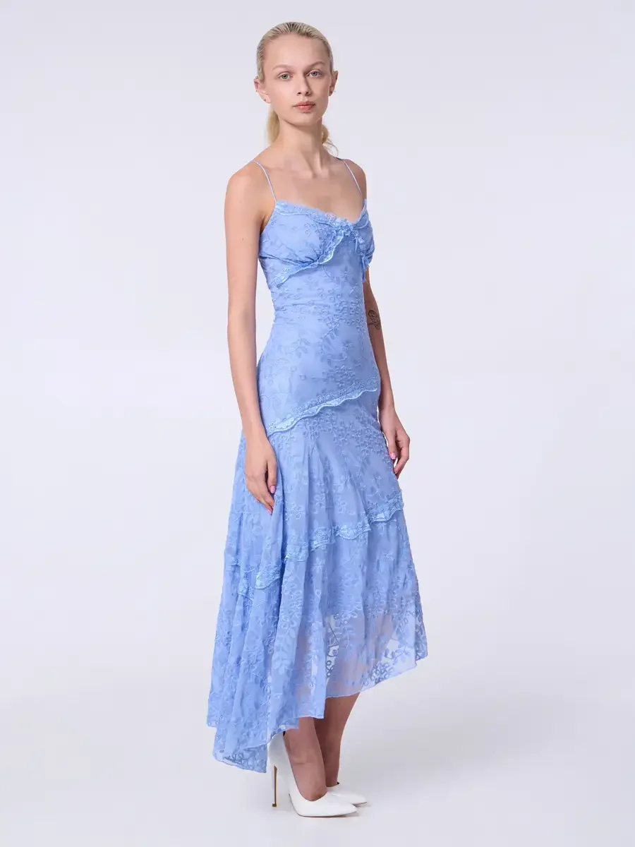 Model portfolio development session, commercial look, periwinkle blue lace asymmetrical midi dress with ruffle bodice detail and spaghetti straps, full-length, three-quarter turn, composed neutral expression, arms relaxed, tiered lace skirt with shee