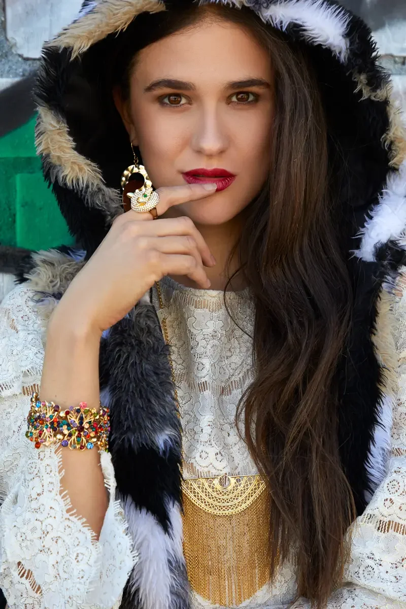 Model portfolio development session, high fashion editorial look, fur-trimmed black and white hood, white lace dress, layered gold chain necklace, multicolor gemstone bracelet, red lip, outdoor location, photographed by Scott Parker Photo, New York