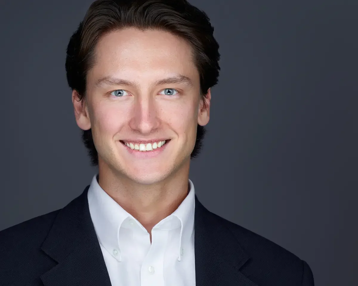 Attorney headshot, navy blazer and white shirt, gray background, photographed by Scott Parker Photo