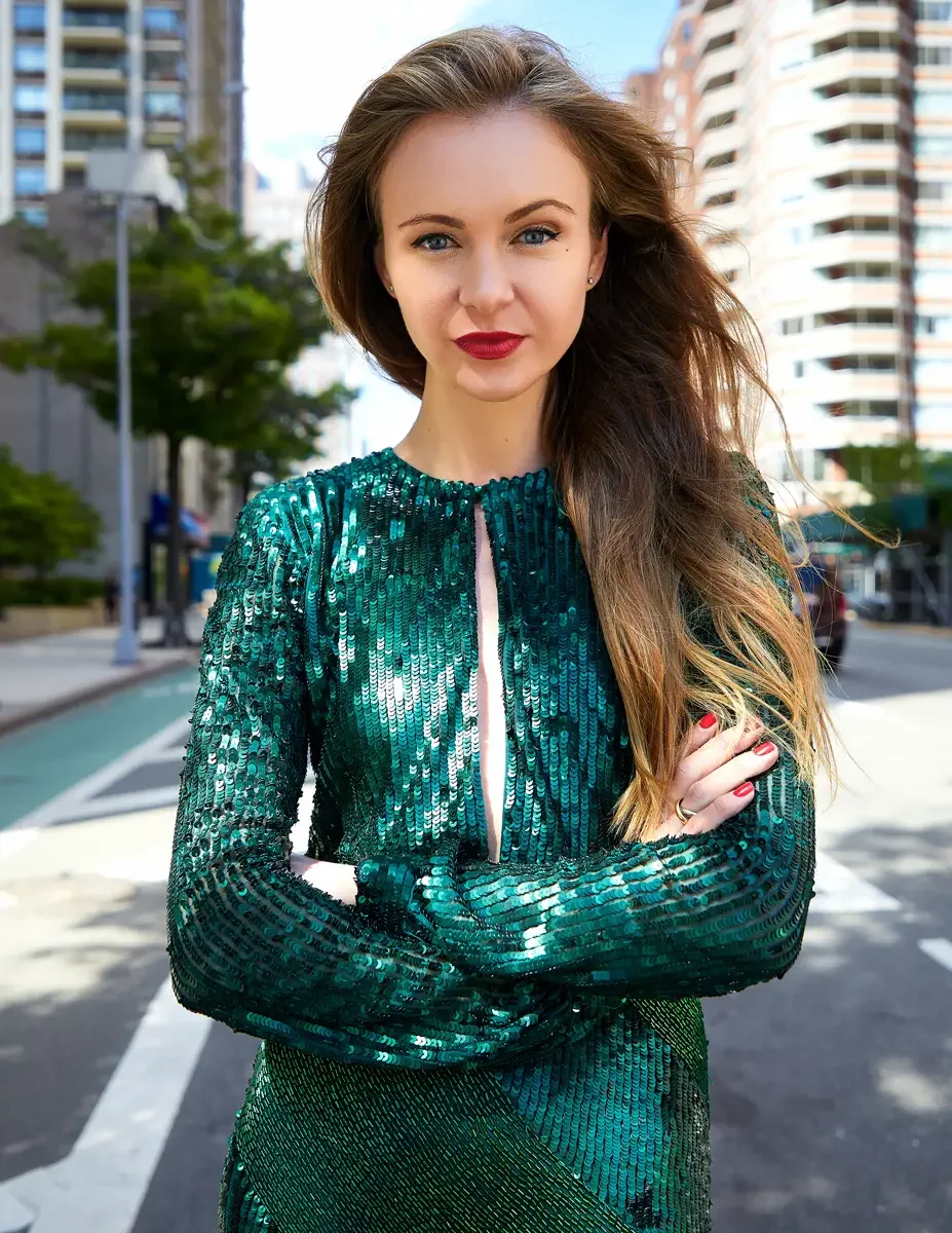 Julia, three-quarter length, standing on an Upper East Side avenue with arms crossed, emerald green sequin long-sleeve mini dress with keyhole cutout neckline, gold band ring, Upper East Side street test shoot, photographed by Scott Parker Photo