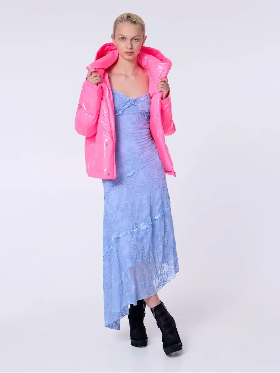 Model portfolio development session, commercial look, hot pink vinyl puffer jacket held open at collar over periwinkle blue lace asymmetrical midi dress, full-length, facing camera, both hands gripping lapels wide open, direct gaze, full lace dress s