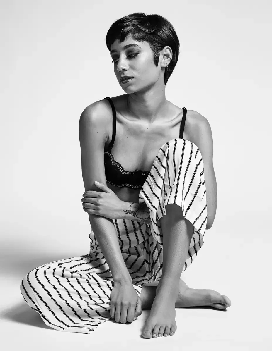 Eloissa, black and white, floor-seated, black lace bralette and striped wide-leg trousers, floral wrist tattoo, East Williamsburg studio test shoot, makeup by Schanica Pickens, photographed by Scott Parker Photo