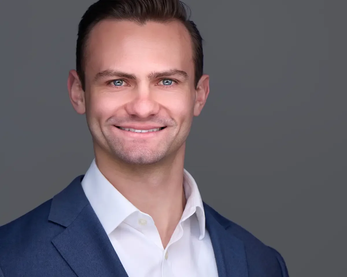 Attorney headshot, blue blazer and white shirt, gray background, photographed by Scott Parker Photo
