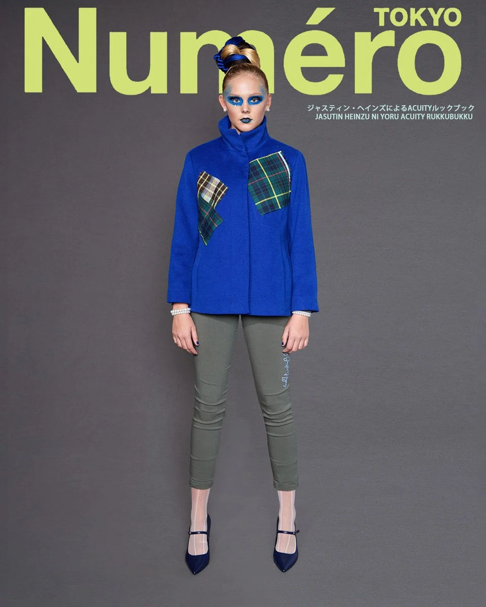 JUS10H by Justin Haynes ACUITY Collection lookbook for Numéro Tokyo by Scott Parker — model in cobalt blue wool funnel-neck jacket with multi-tartan patchwork pockets, paired with olive green skinny trousers featuring signature embroidery, sheer tigh