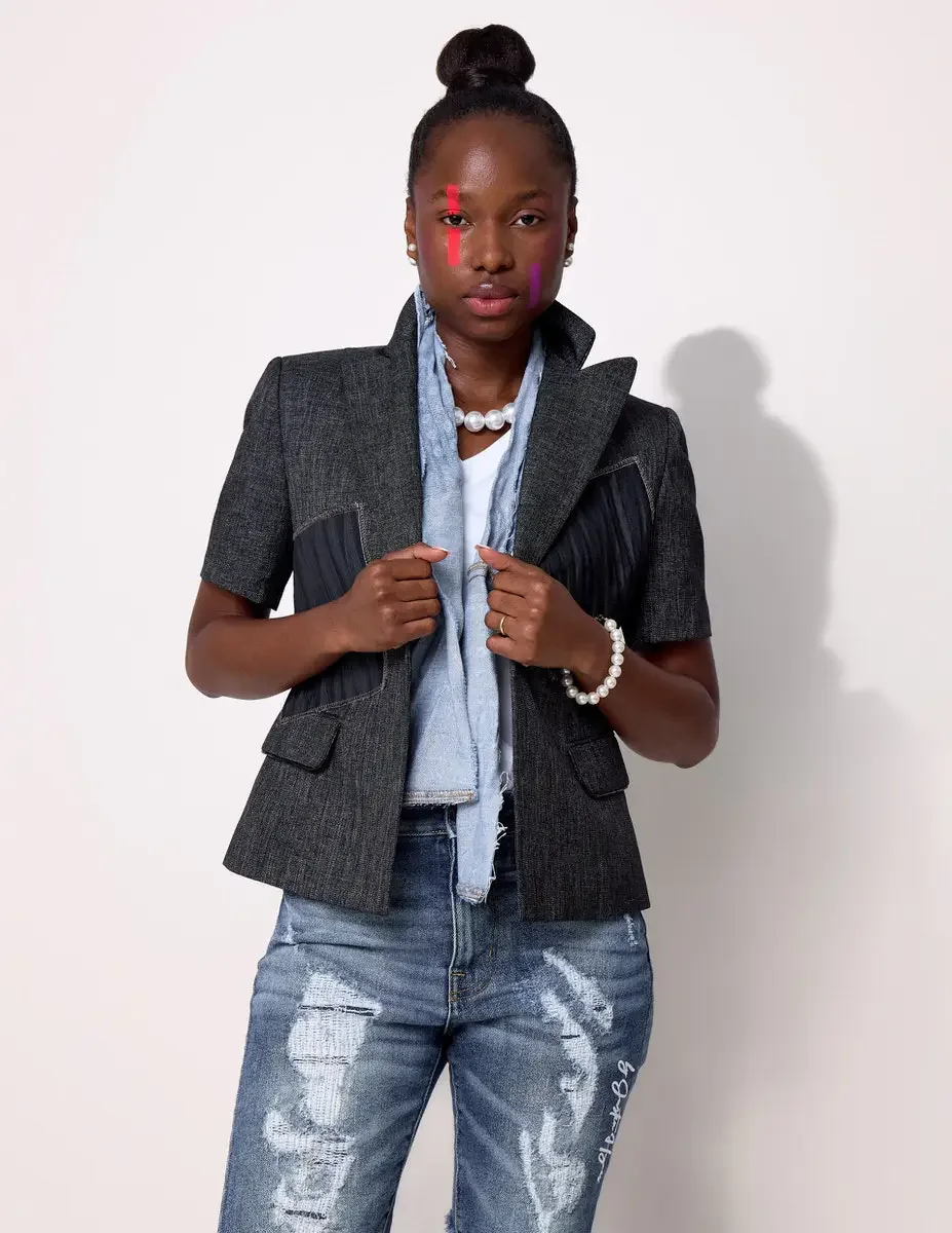 JUS10H Black Summer Jacket editorial, close portrait of female model in dark denim structured vest layered over light blue denim, pearl necklace and bracelet, distressed JUS10H jeans, white background, photographed by Scott Parker Photo