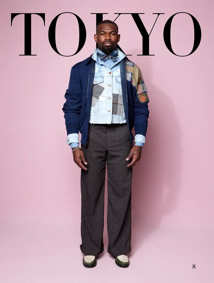 JUS10H 2025 Tokyo lookbook, navy bomber over patchwork denim jacket and charcoal wide leg trousers with bow tie detail, pink background, photographed by Scott Parker Photo for the Tokyo Fashion Council