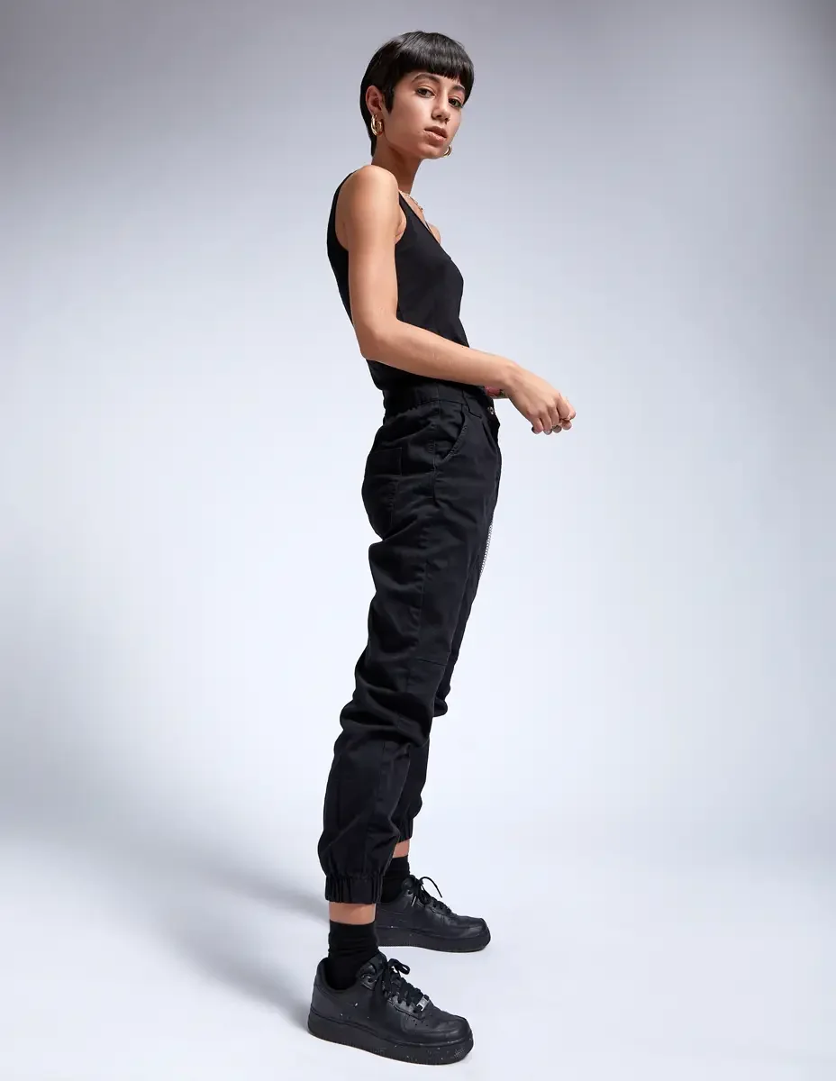 Eloissa, profile, black tank and black cargo jogger pants, black Nike sneakers, East Williamsburg studio test shoot, makeup by Schanica Pickens, photographed by Scott Parker Photo