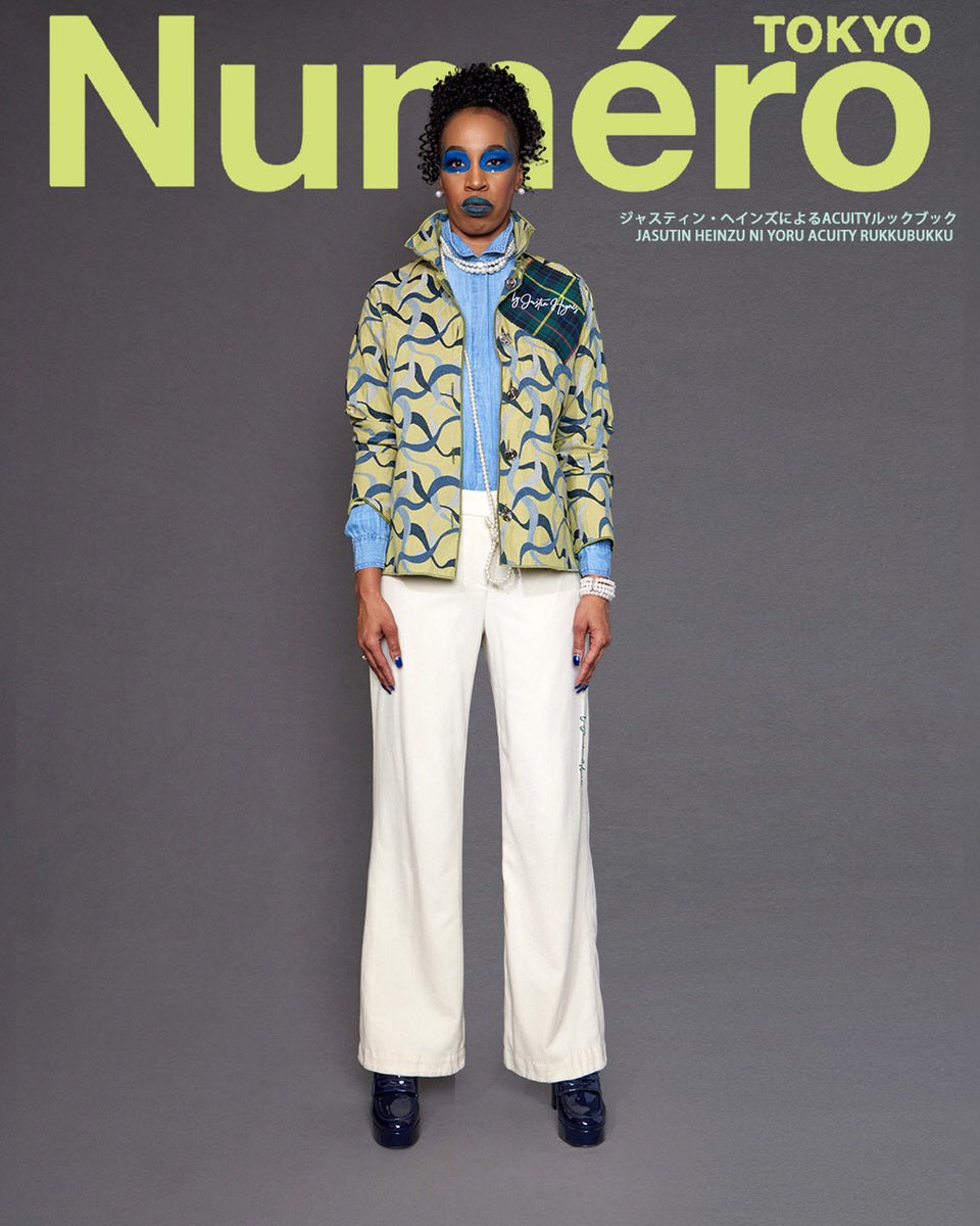 JUS10H by Justin Haynes ACUITY Collection lookbook for Numéro Tokyo by Scott Parker — model in chartreuse and navy ribbon-print quilted jacket with tartan shoulder patch and signature embroidery, layered over chambray button-down and pale blue knit, 