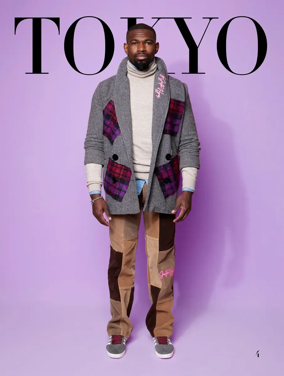 JUS10H 2025 Tokyo lookbook, grey herringbone blazer with purple and red tartan patchwork over cream turtleneck and tan corduroy patchwork trousers, lavender background, photographed by Scott Parker Photo for the Tokyo Fashion Council