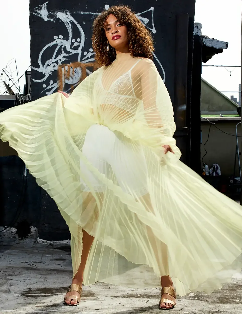 Fashion test shoot, model Ireland T in J'Amemme yellow pleated sheer gown, Taro Collection earrings, graffiti wall backdrop, East Village rooftop, New York City, styling by Matsine Stinson, makeup by Stefani Paige Vivian, photographed by Scott Parker