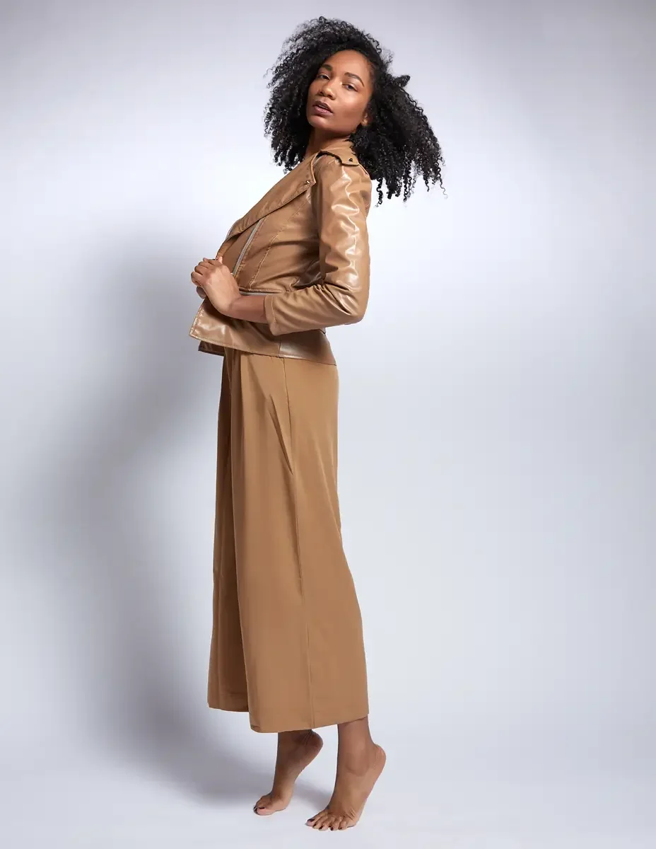 Arielle Chambers, three-quarter turn, camel patent leather moto jacket and wide-leg trousers, East Williamsburg studio test shoot, makeup by Schanica Pickens, photographed by Scott Parker Photo