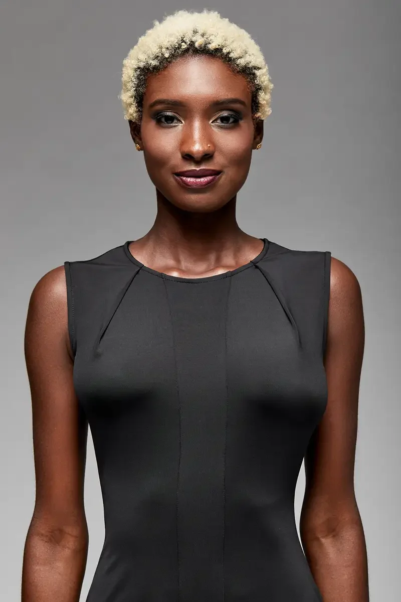 Minika Ko lookbook, detail, black sleeveless bodycon dress, close crop showing crew neckline and angled raglan-style seam at shoulder and upper bodice, photographed by Scott Parker Photo