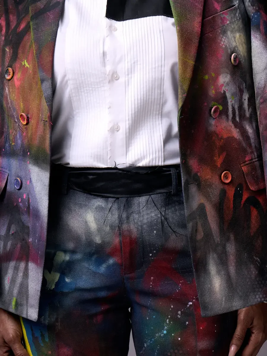 JUS10H Met Monday 2026, open blazer detail revealing white pleated tuxedo shirt and black cummerbund, hand-painted fabric, grey background, photographed by Scott Parker Photo