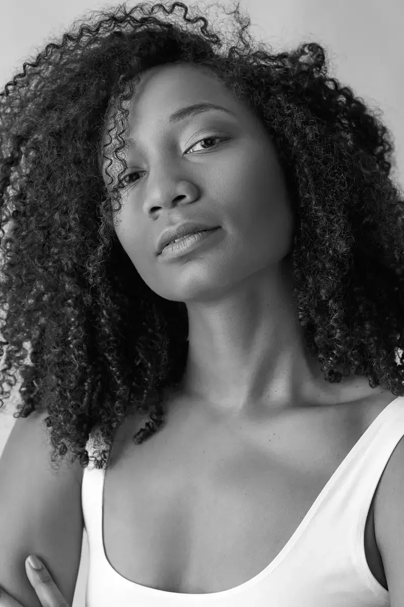 Arielle Chambers, white tank and burgundy wide-leg pleated pants, studio stool, East Williamsburg studio test shoot, makeup by Schanica Pickens, photographed by Scott Parker Photo