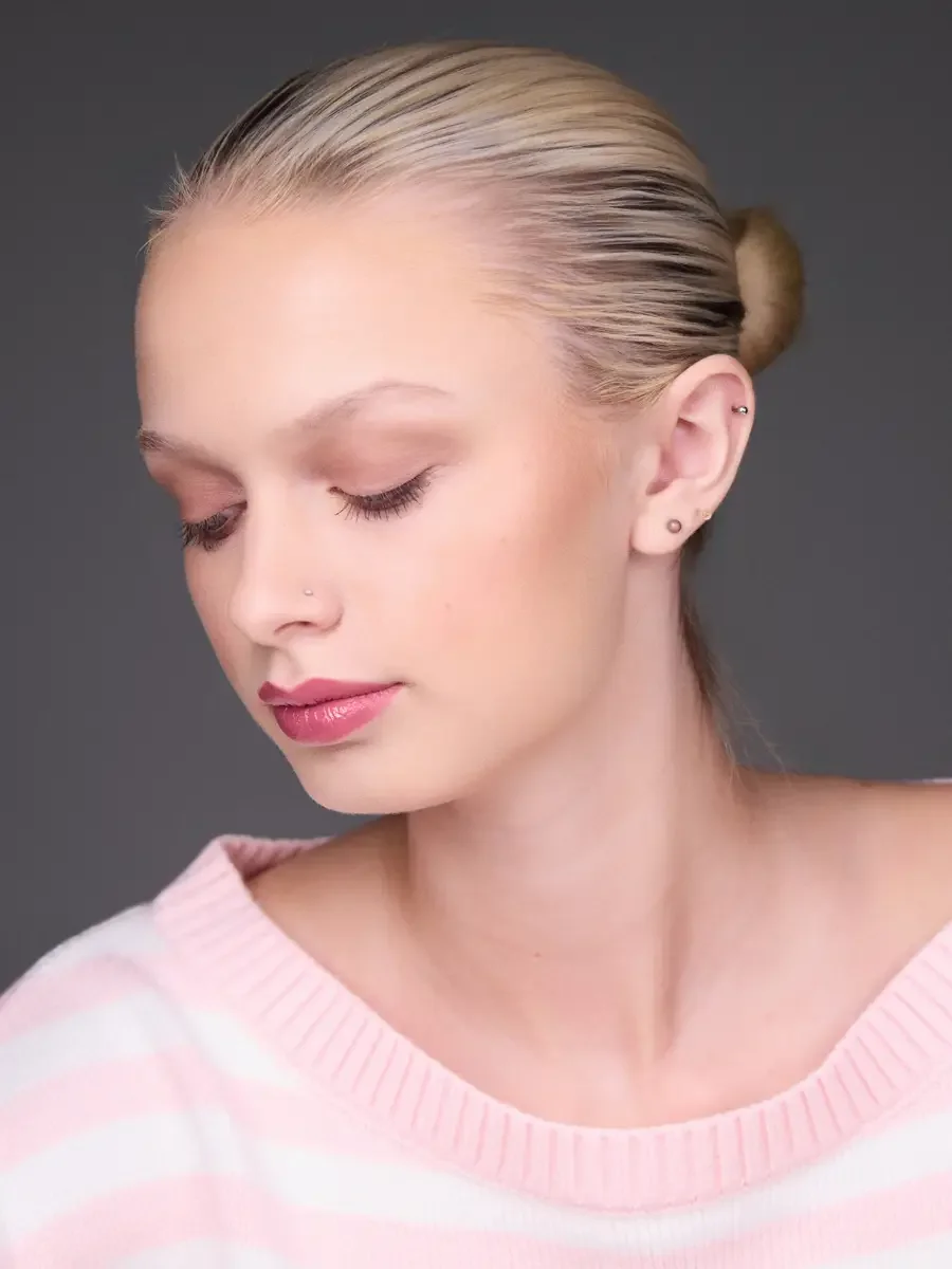 Model portfolio development session, beauty, close-crop, hair in low bun, three-quarter turn, eyes closed, rose lip, soft eye, pink striped sweater, gray background, photographed by Scott Parker Photo, New York