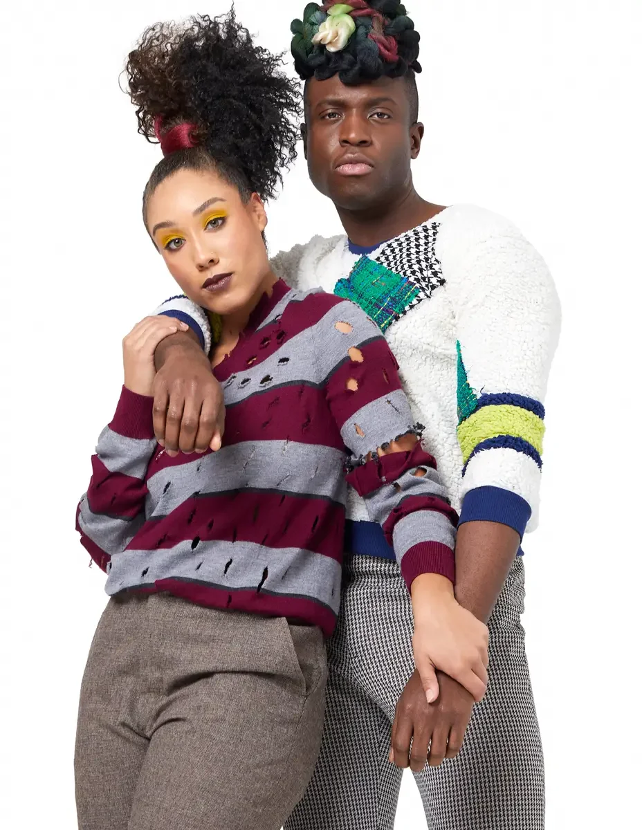 Model portfolio development session, high fashion editorial look, two models close together, woman in burgundy and heather grey destroyed-knit stripe sweater, man in white patchwork bouclé knit sweater with houndstooth and multicolor tweed appliqué p
