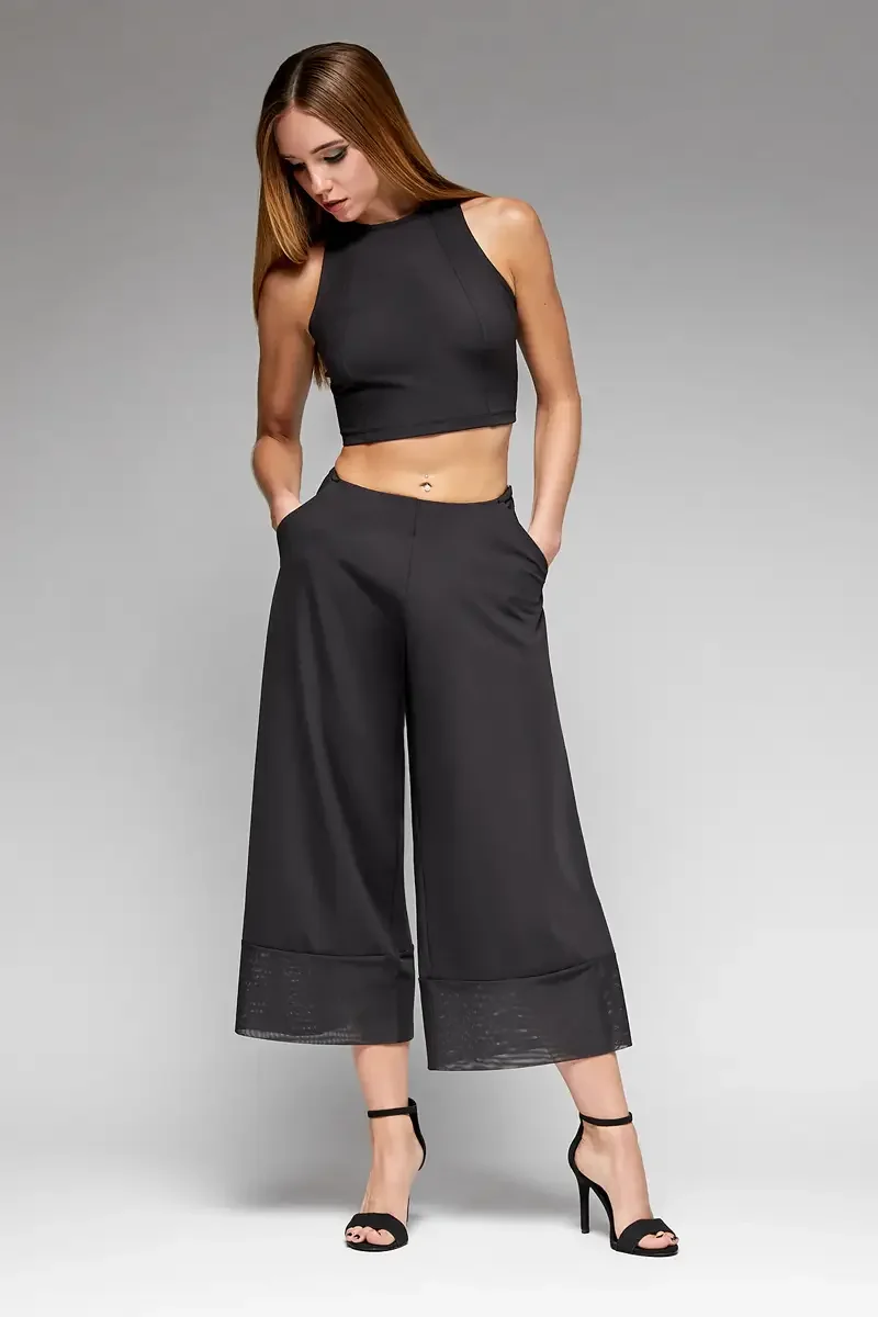 Minika Ko lookbook, black halter crop top and wide-leg culottes set, front view, high waist, side pockets, sheer mesh cuff at hem, smooth synthetic fabric, photographed by Scott Parker Photo