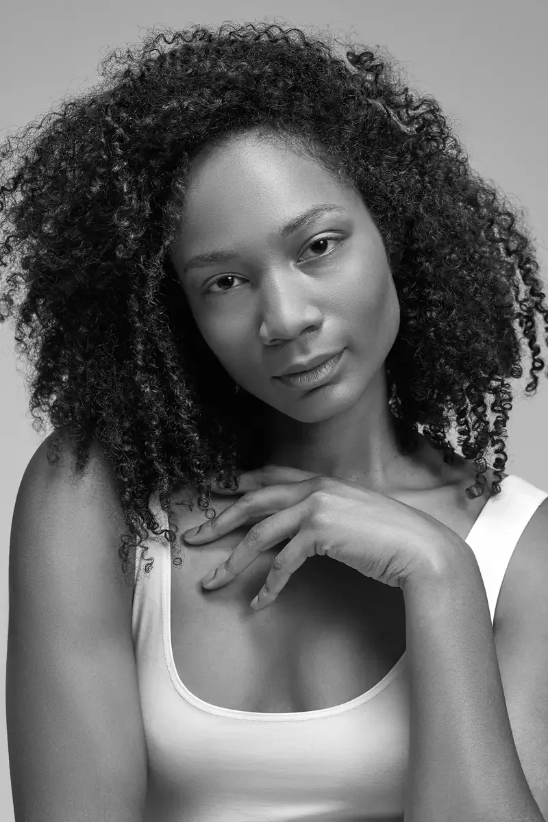 Arielle Chambers, seated, white tank and burgundy wide-leg pleated pants, studio cyc wall, East Williamsburg studio test shoot, makeup by Schanica Pickens, photographed by Scott Parker Photo
