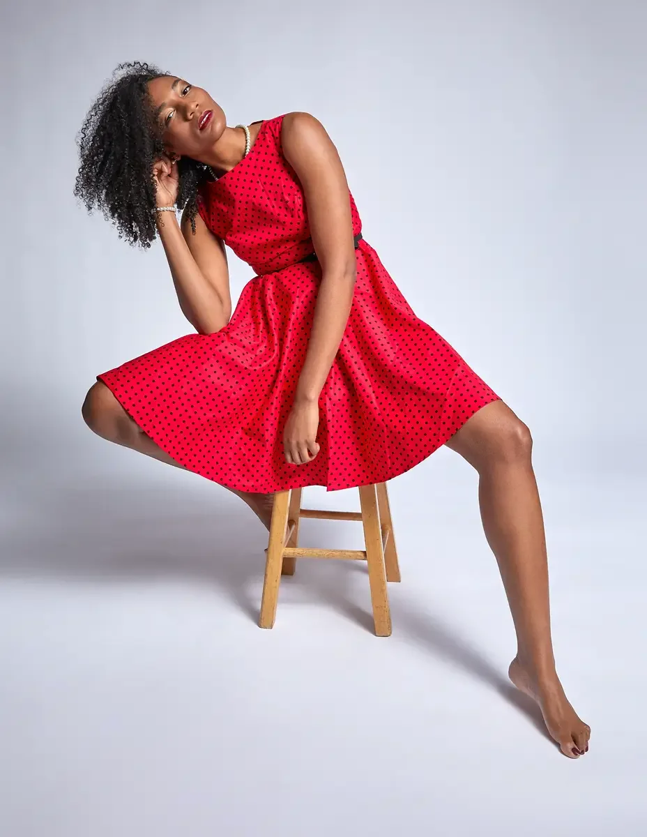 Arielle Chambers, seated, red polka dot dress, gaze off frame, pearl necklace, East Williamsburg studio test shoot, makeup by Schanica Pickens, photographed by Scott Parker Photo