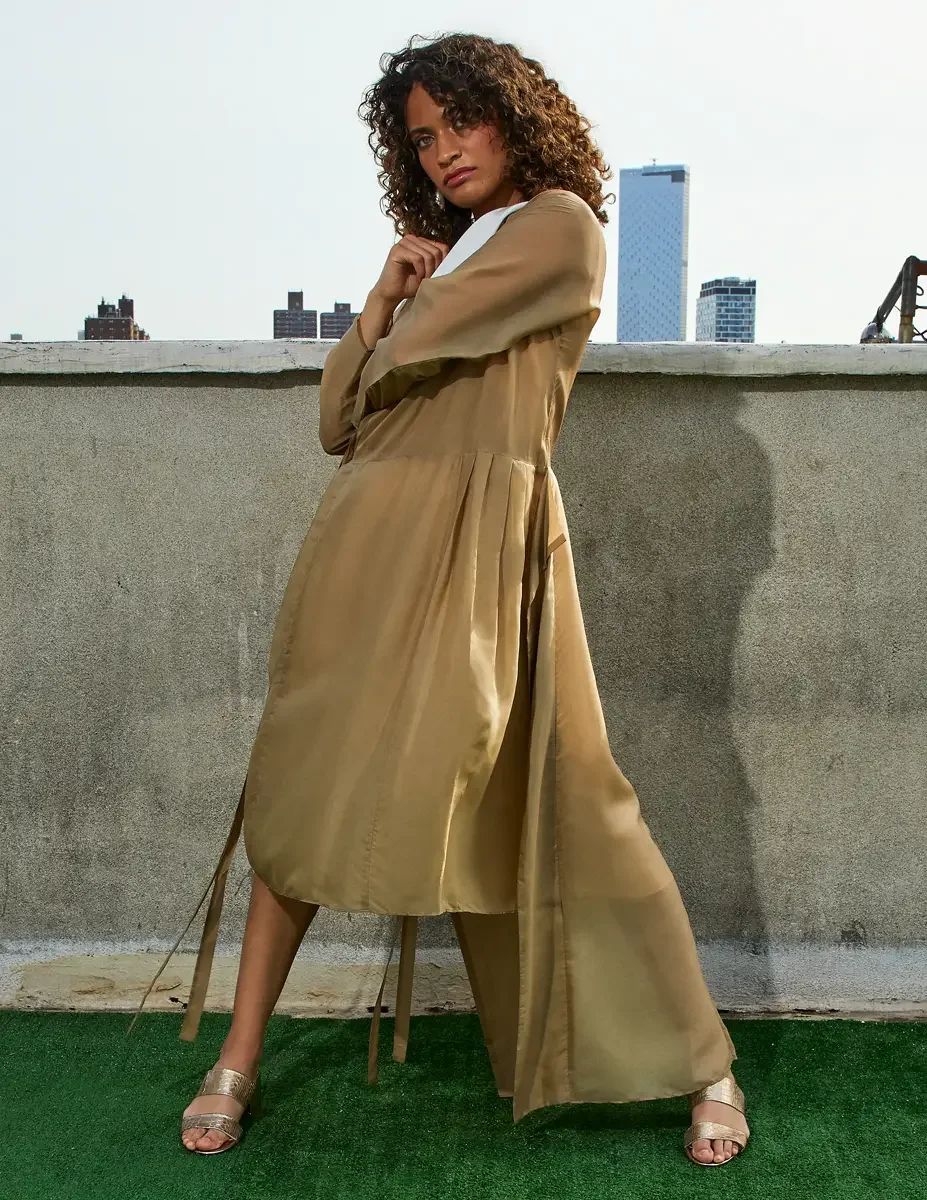 Fashion test shoot, three-quarter, model Ireland T in a gold satin wrap dress with white collar and tie belt, Manhattan skyline, East Village rooftop, New York City, styling by Matsine Stinson, makeup by Stefani Paige Vivian, photographed by Scott Pa
