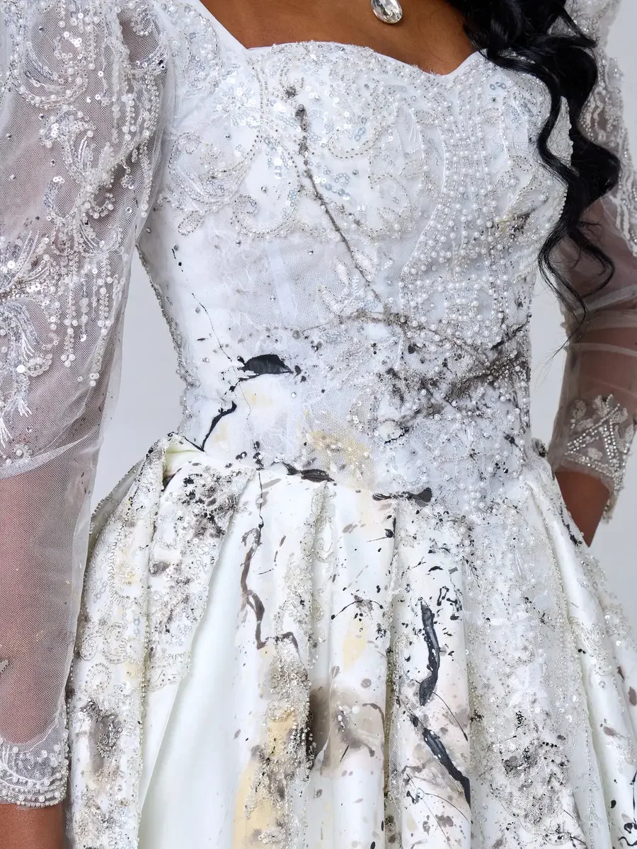 JUS10H 2025 New York Bridal Fashion Week, close detail of white beaded sweetheart bodice with pearl and crystal embroidery transitioning into an abstract paint-splatter ball gown skirt, with sheer beaded lace sleeves, photographed by Scott Parker Pho