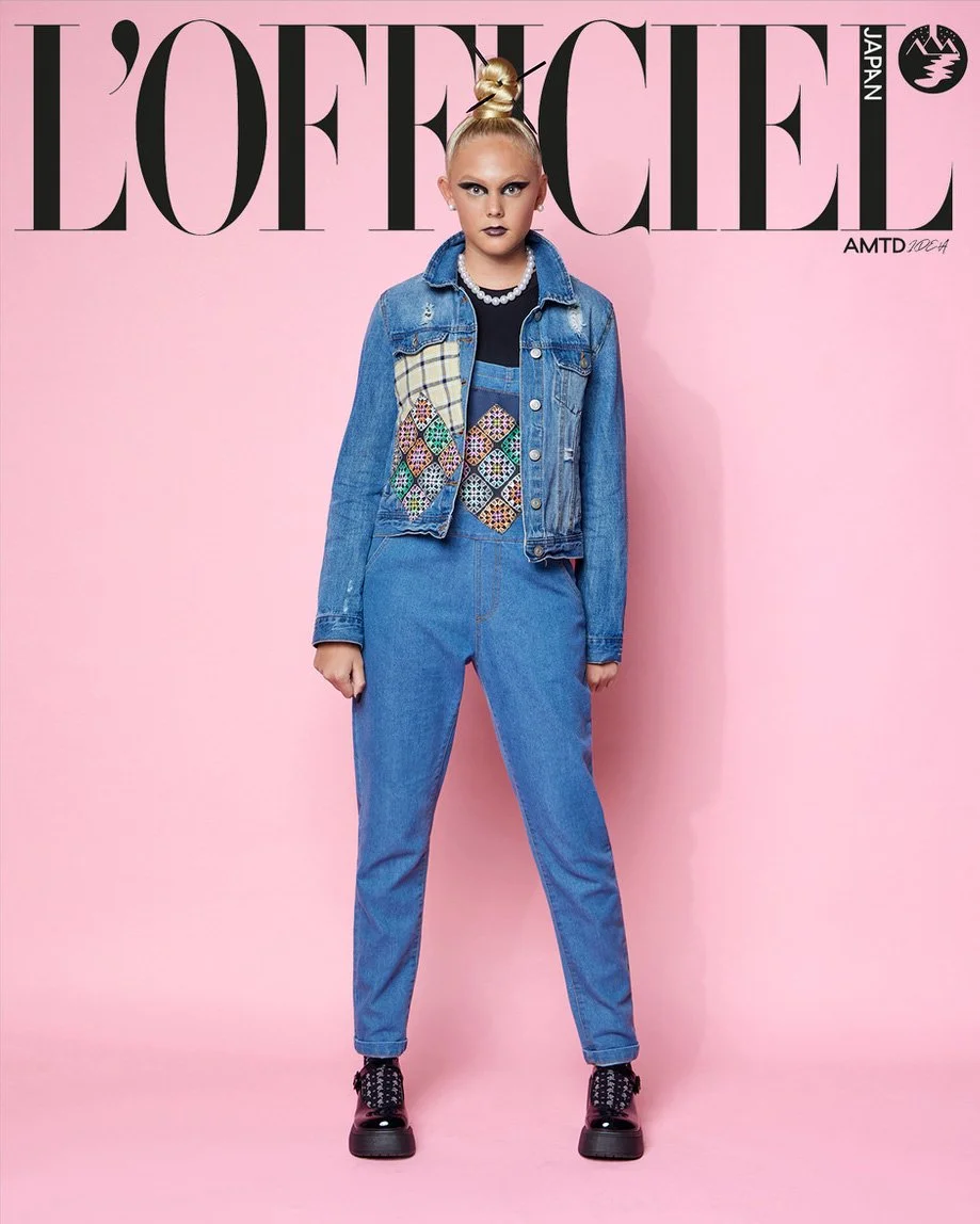 

JUS10H Tokyo Remote Collection NYFW 2025 — model Hadley in medium-wash distressed denim trucker jacket with plaid and multicolor mosaic embroidered diamond patchwork over a light-wash denim jumpsuit with red stitch detailing, pearl choker necklace,