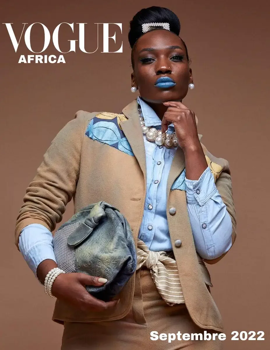 JUS10H 2022 Vogue Africa feature, editorial cover, camel patchwork blazer over chambray shirt, oversized pearl necklace and bracelet, blue lip, warm brown background, photographed by Scott Parker Photo