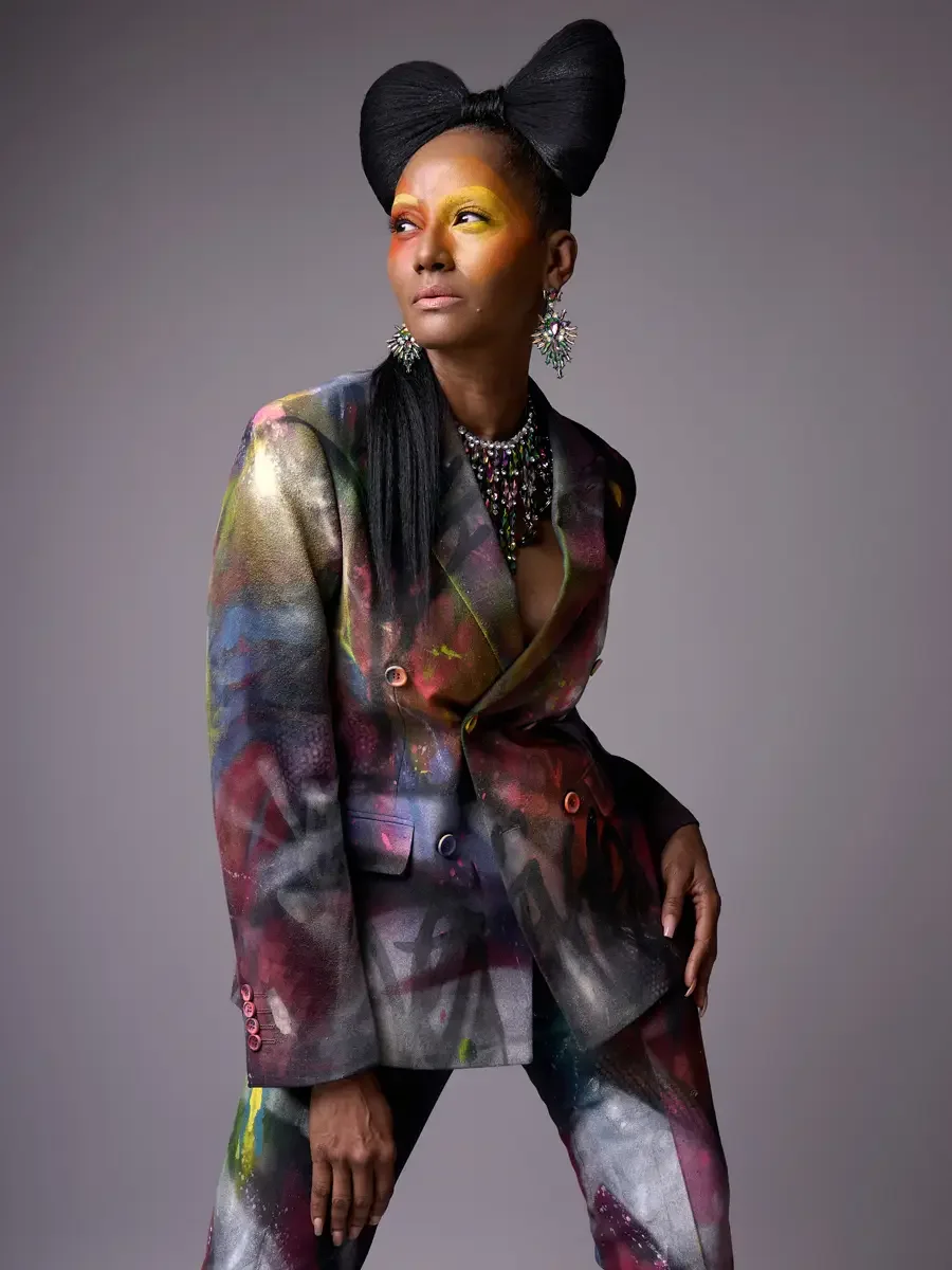 JUS10H Met Monday 2026, three-quarter view hand-painted suit, iridescent bib necklace and starburst earrings, grey background, photographed by Scott Parker Photo